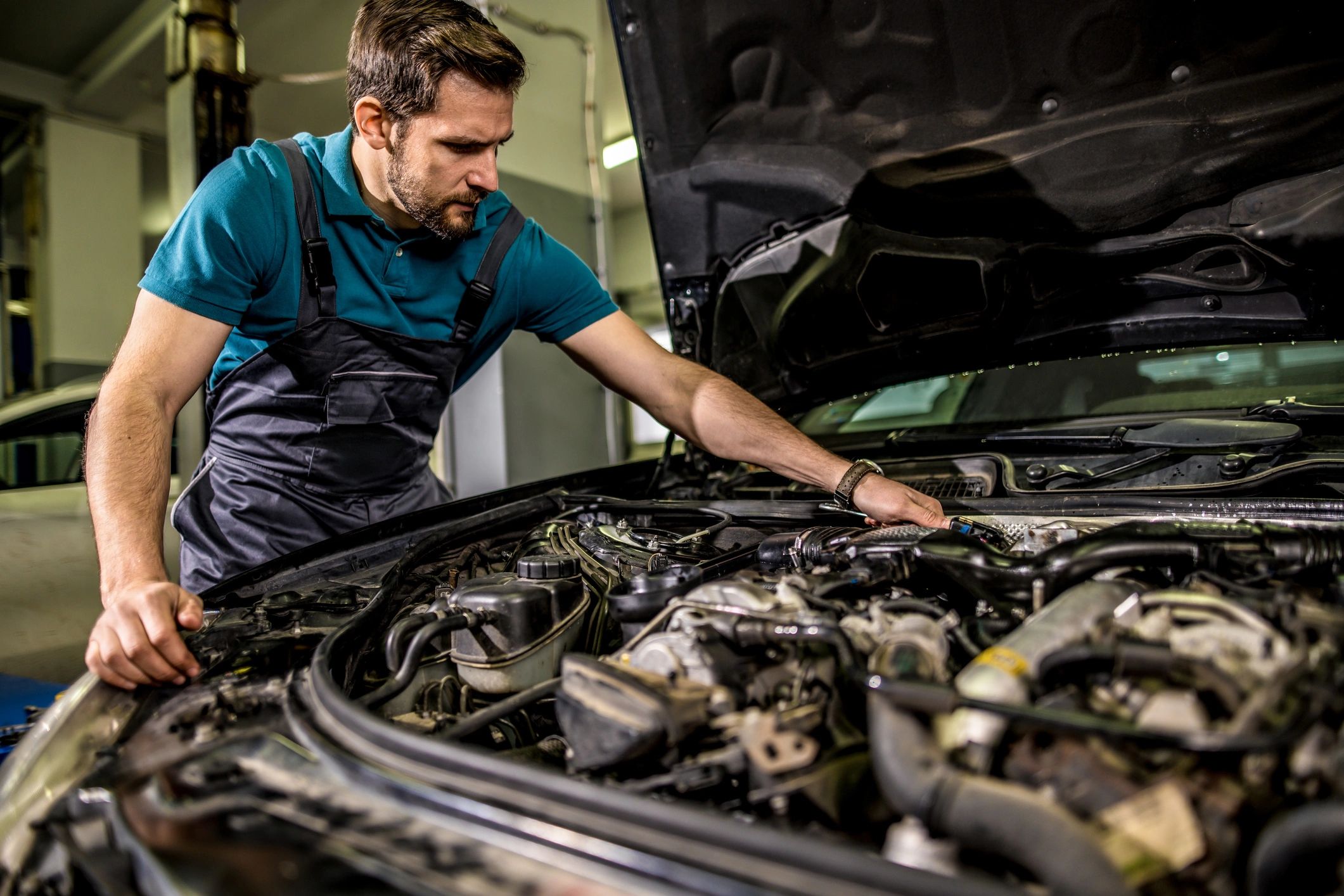 Auto mechanic examining an engine at a repair shop