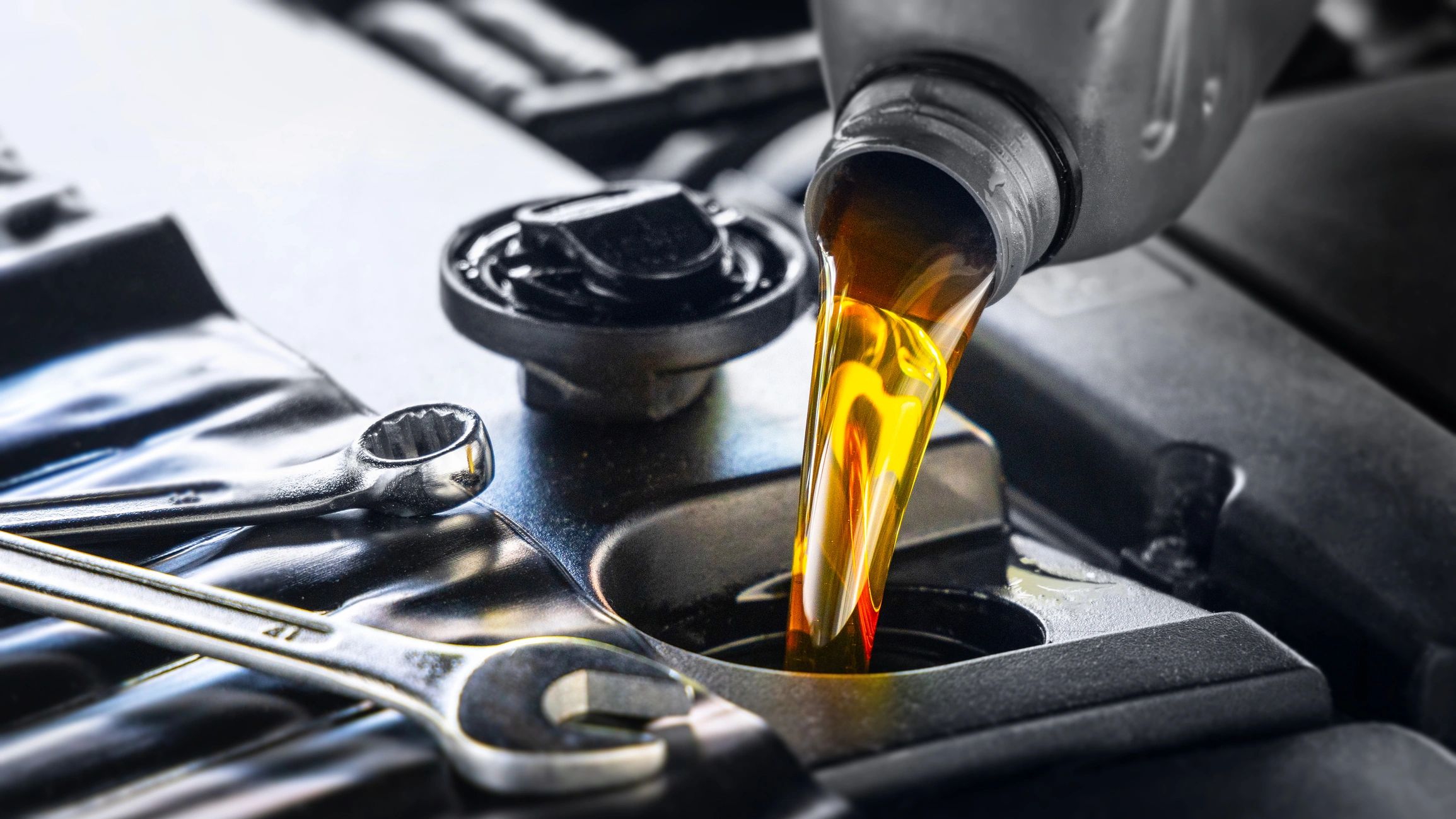 Technician pouring automotive fluid during a service