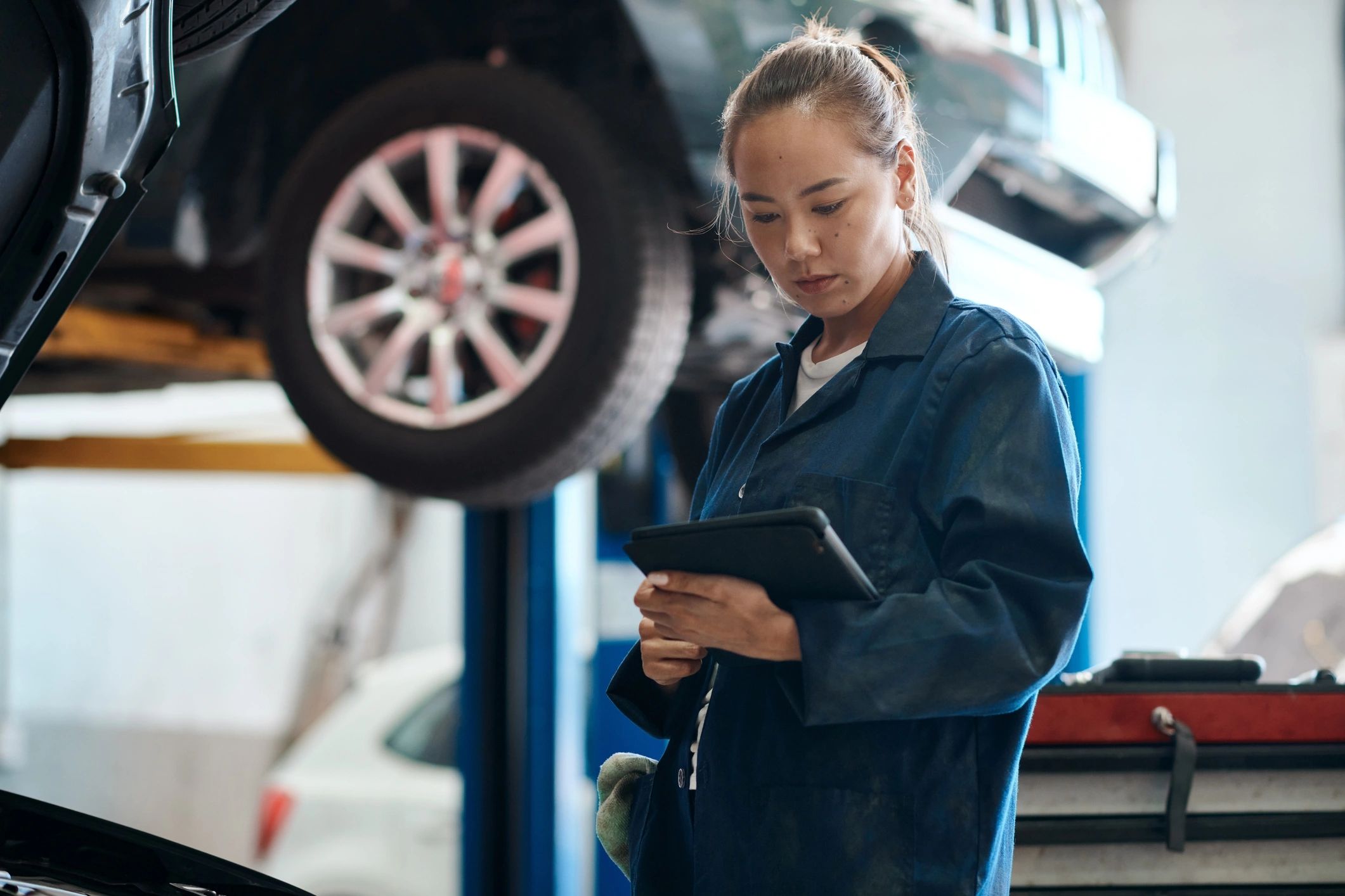 Technician reviewing service details on a tablet in an auto repair shop