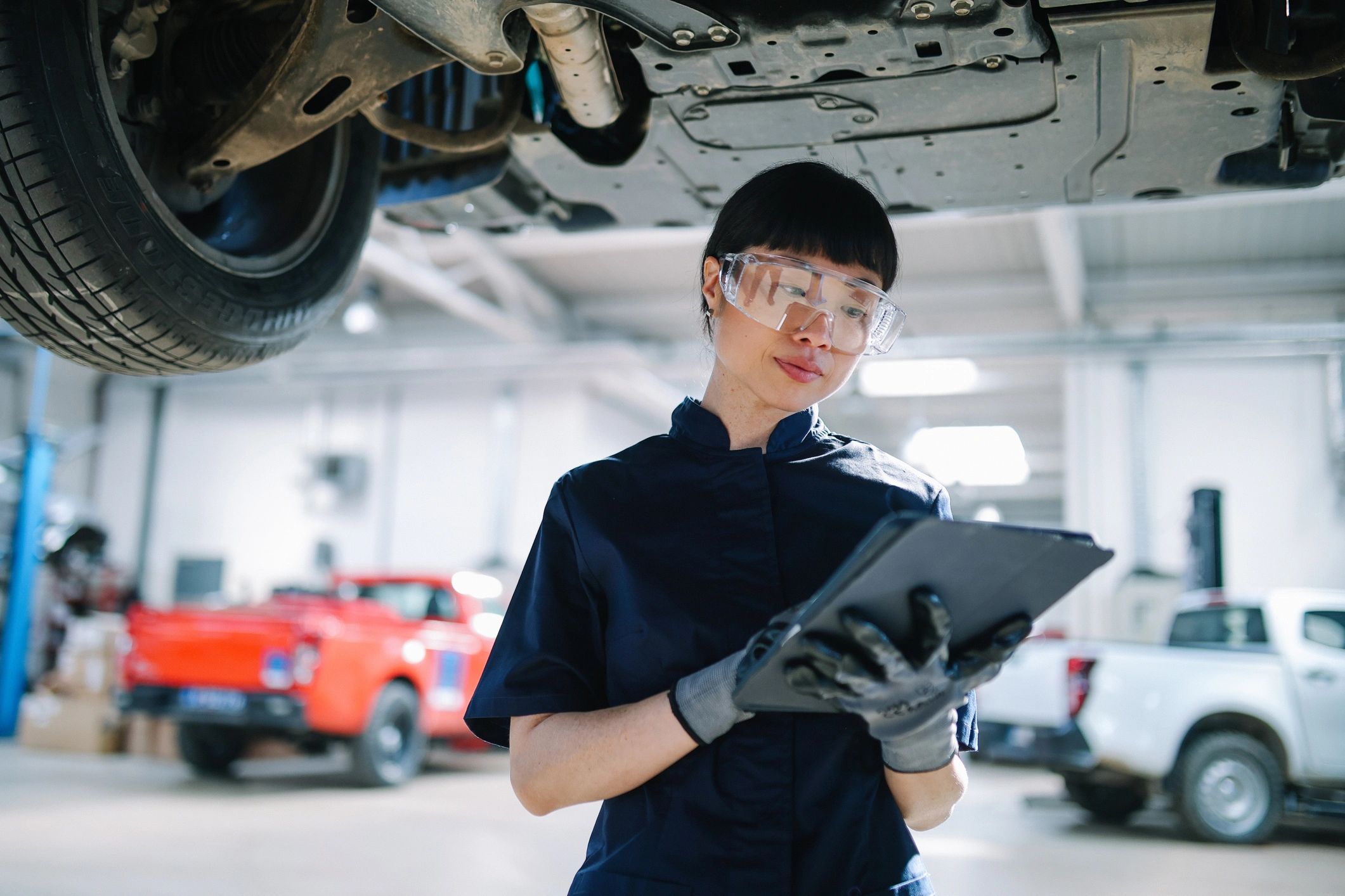 Mechanic using a tablet in an auto repair shop