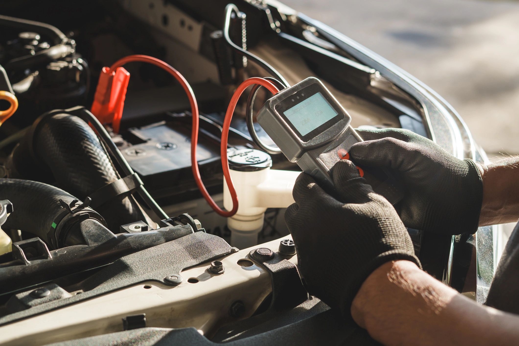 Mechanic using a diagnostic tool under the hood