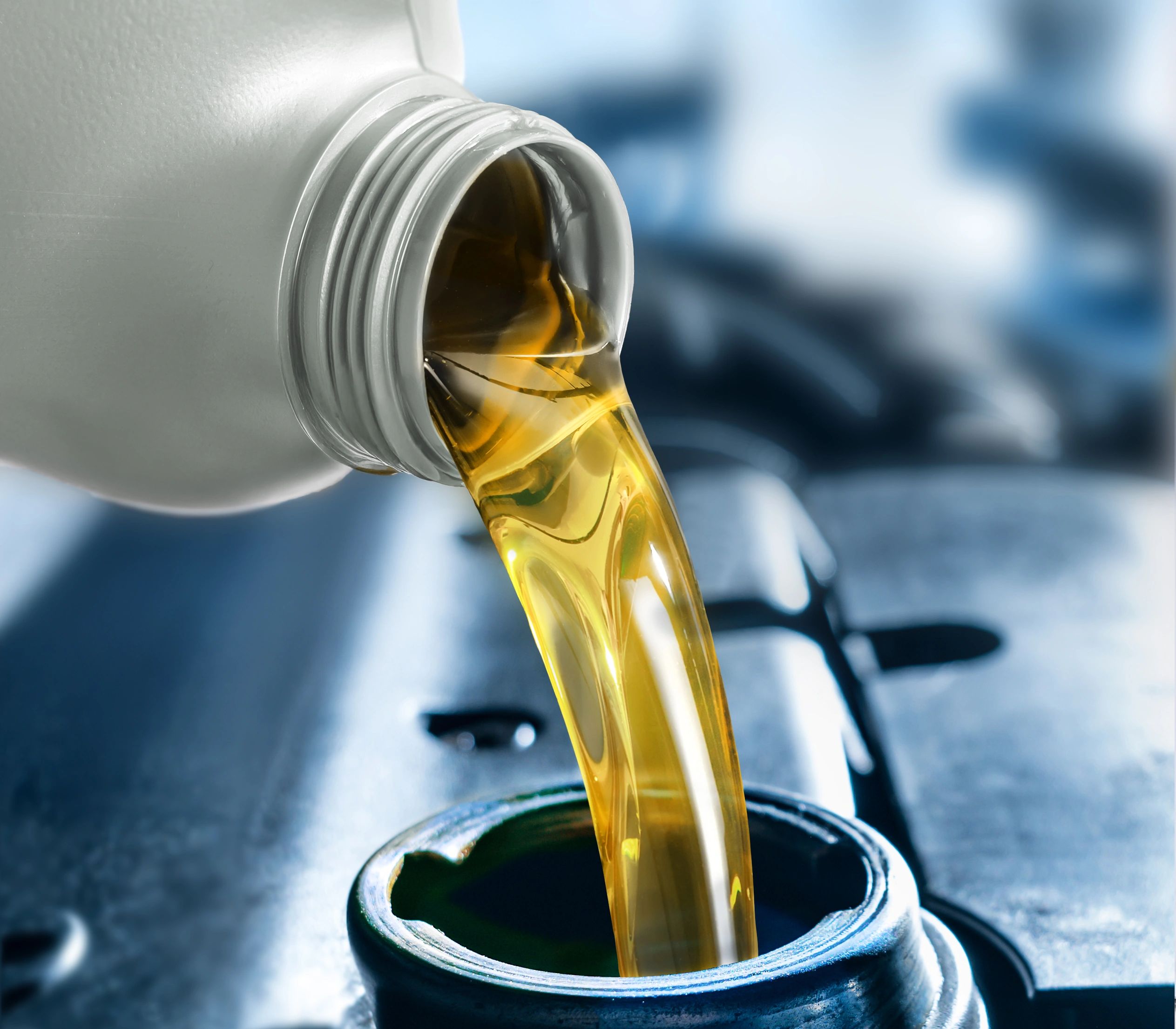 Pouring motor oil into a car engine